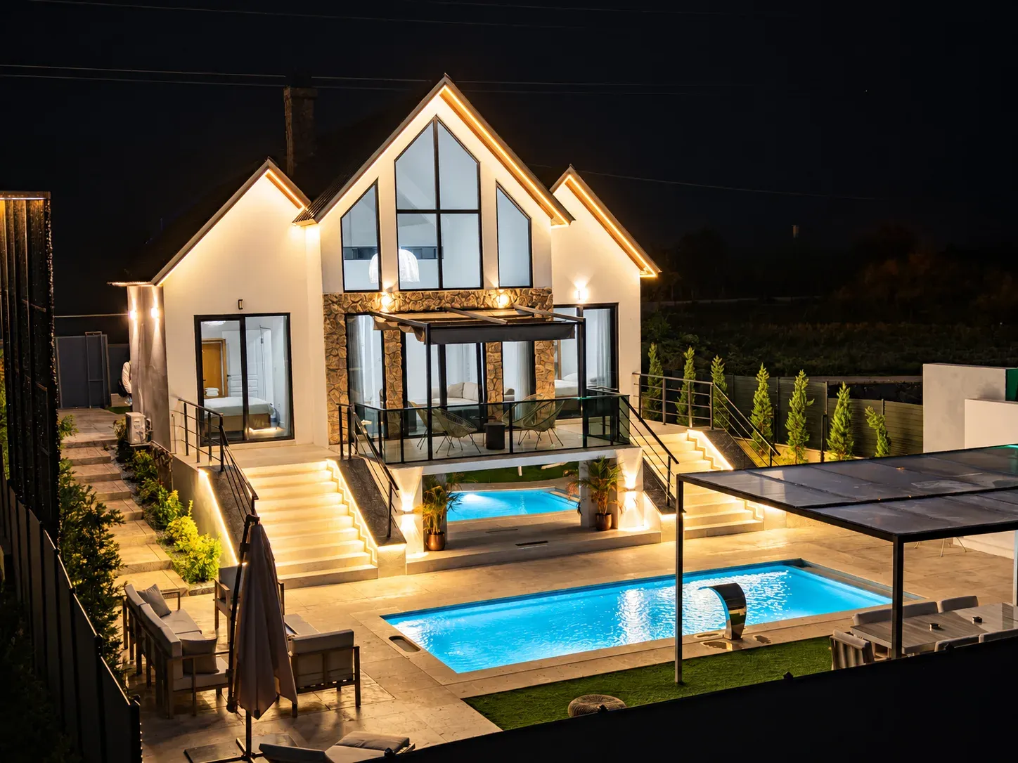 Sunshine Prime'ın iki havuzlu bahçesinin gece görünümü