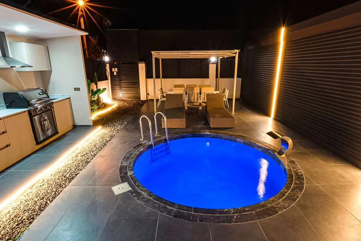 Gece aydınlatmalı yuvarlak havuz ve pergola